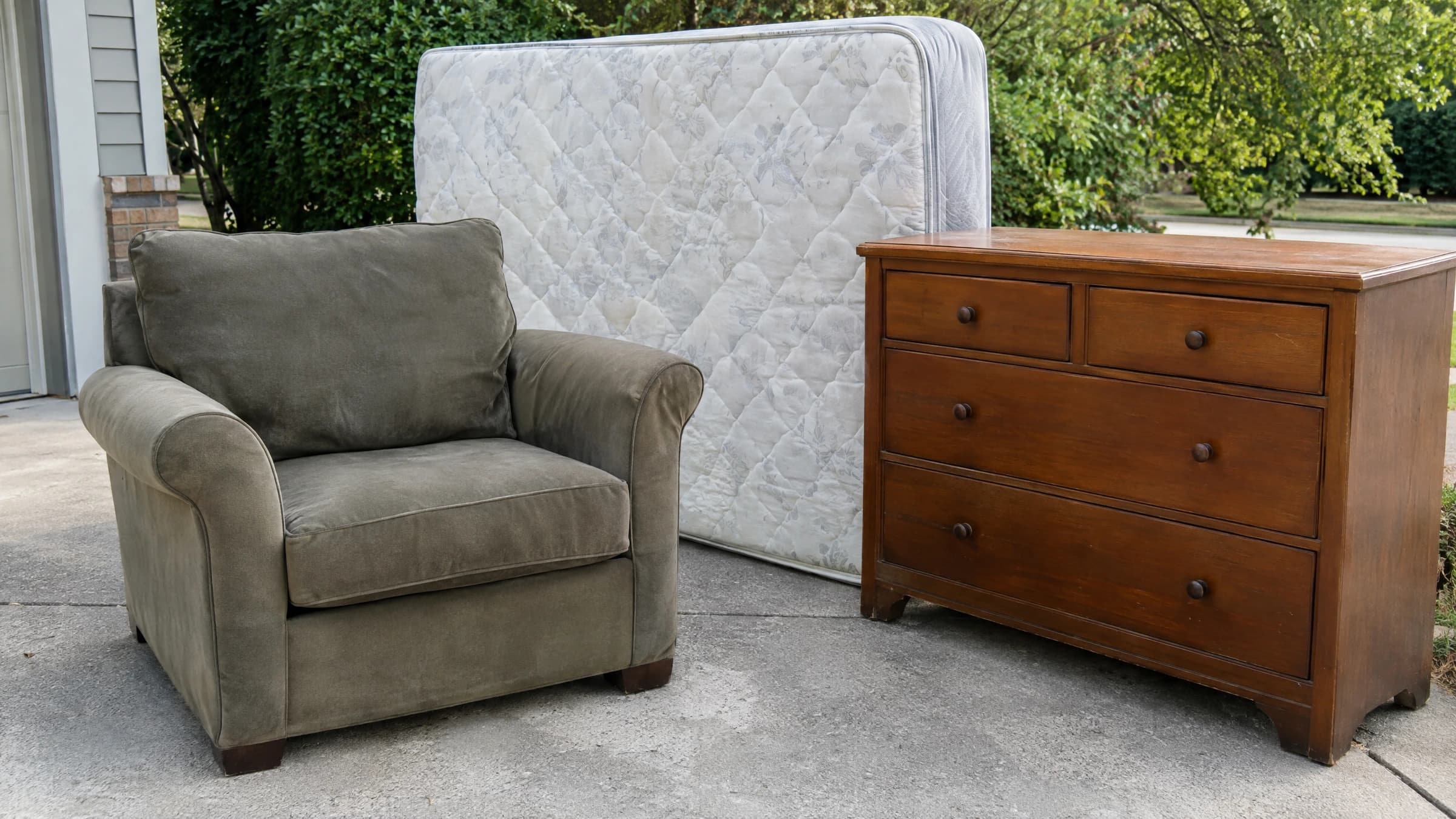 A large armchair, mattress and dresser in a household pickup staging area.