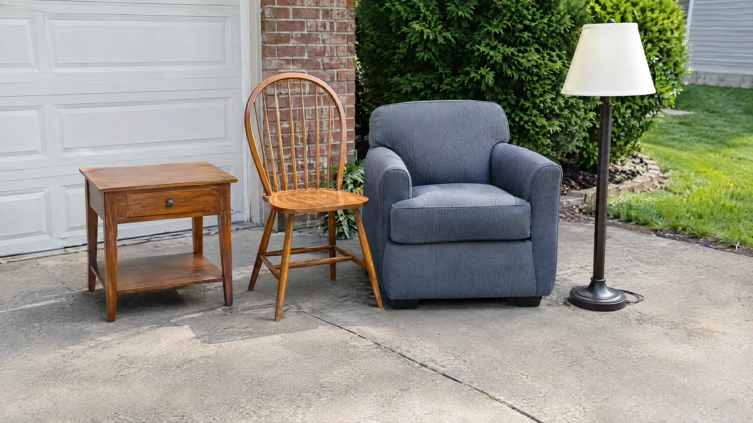 A clearly separated group of household items on a private driveway with no people present.