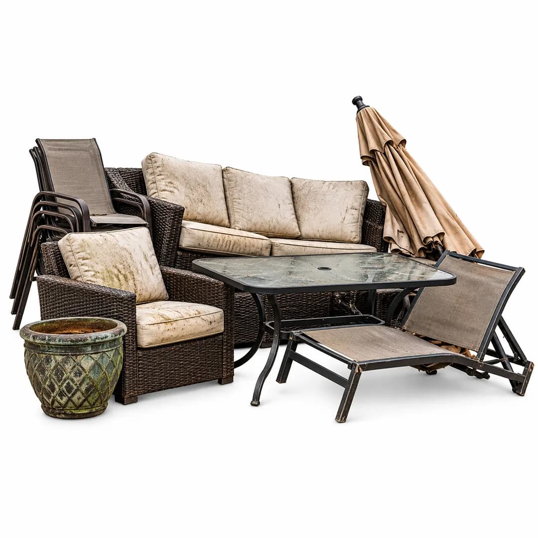 Outdoor sofa, chairs, glass-top table and folded umbrella on a white background